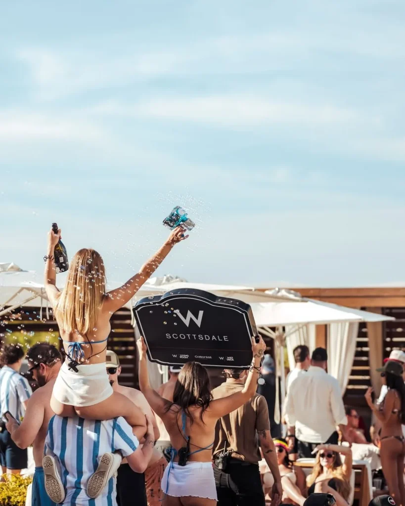 girl outside holding drink while sitting on a man's shoulders